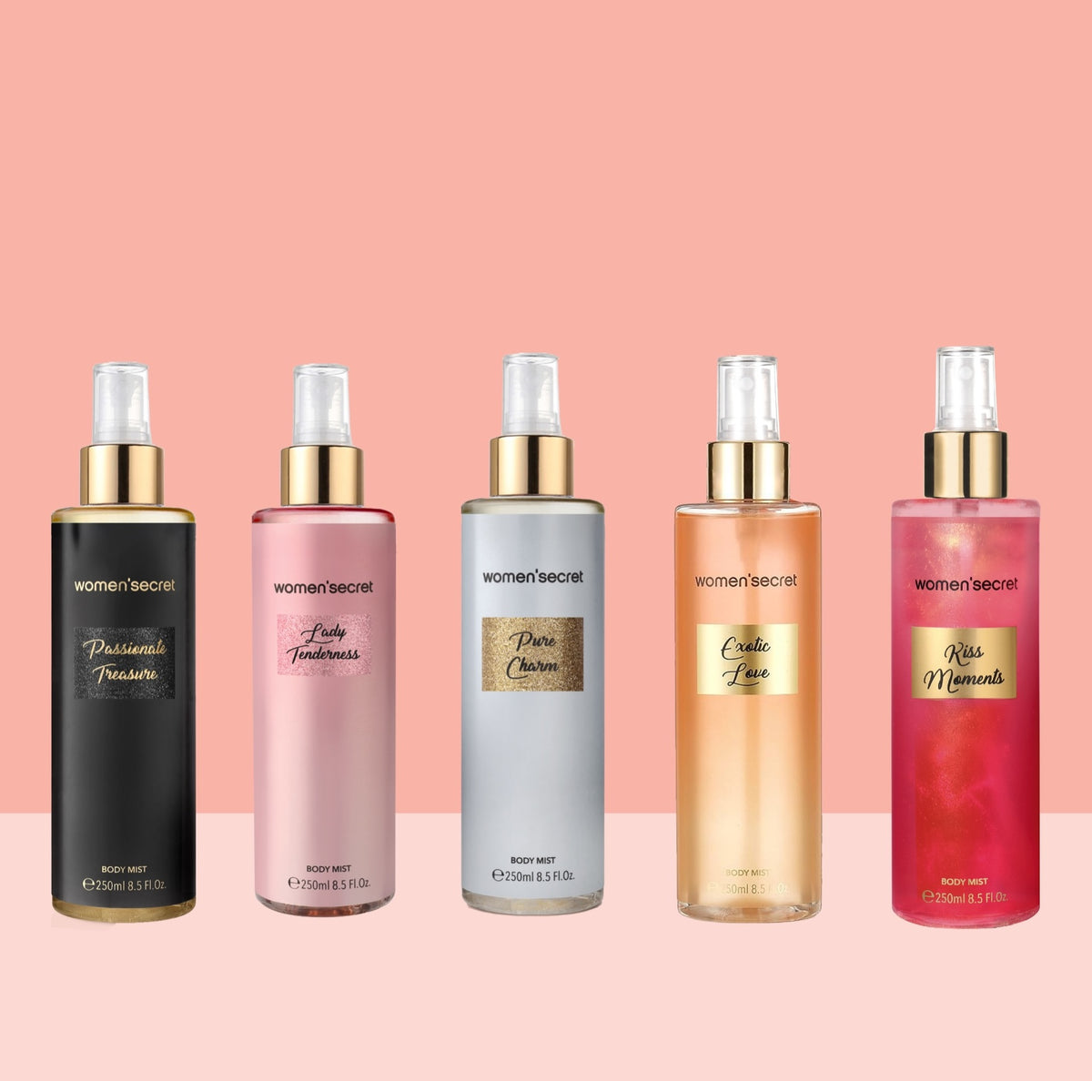 Four Woman Secret body spray bottles lined up against a pink background. The bottles are black, pink, silver, and peach, each with gold lettering and gold caps.